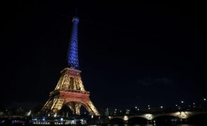 Centenas reuniram-se perto da Torre Eiffel iluminada com as cores do país