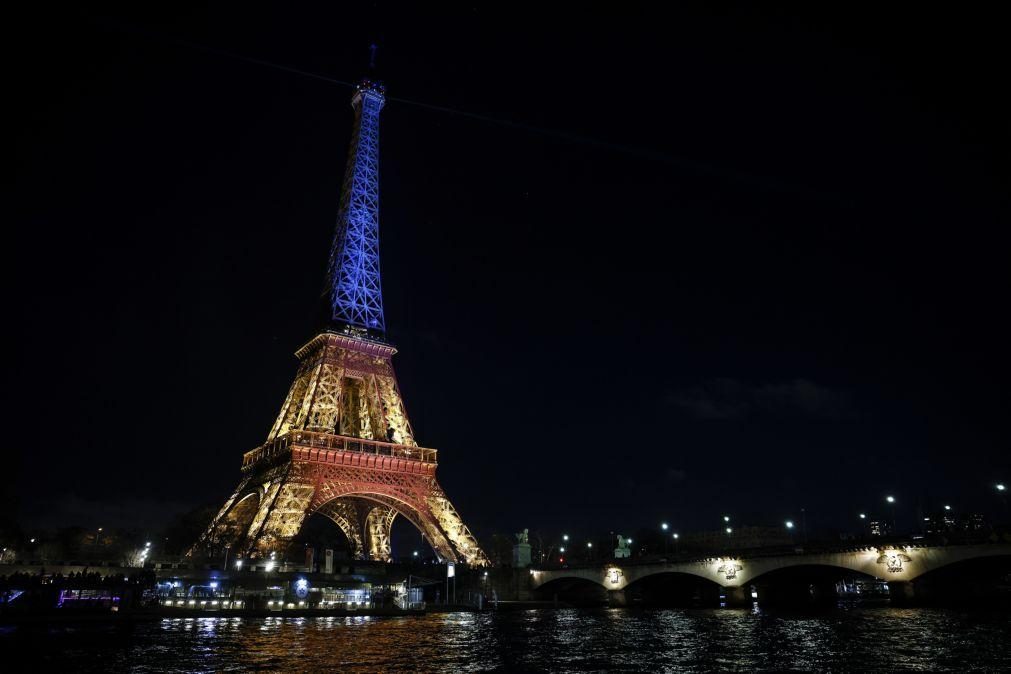 Centenas reuniram-se perto da Torre Eiffel iluminada com as cores do país